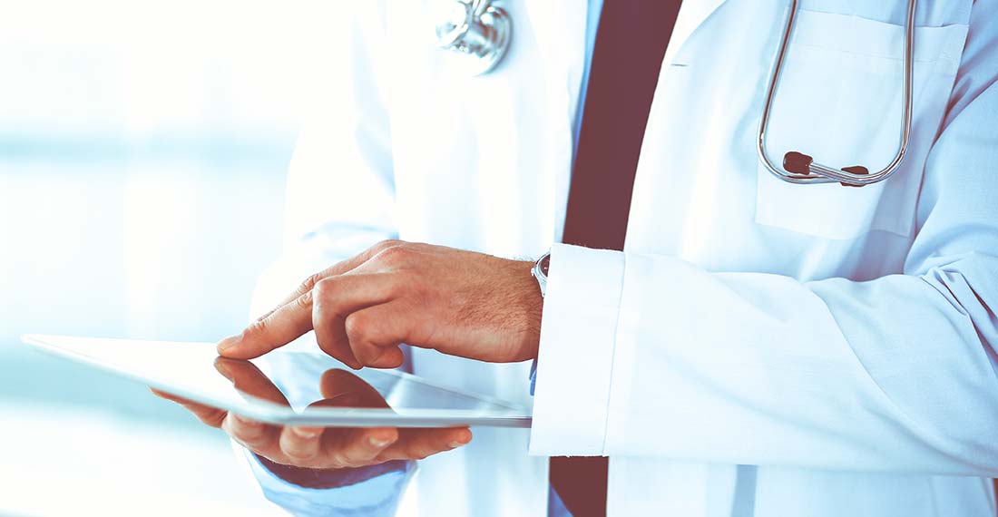 мужчина врач в белом халате с планшетом в руках